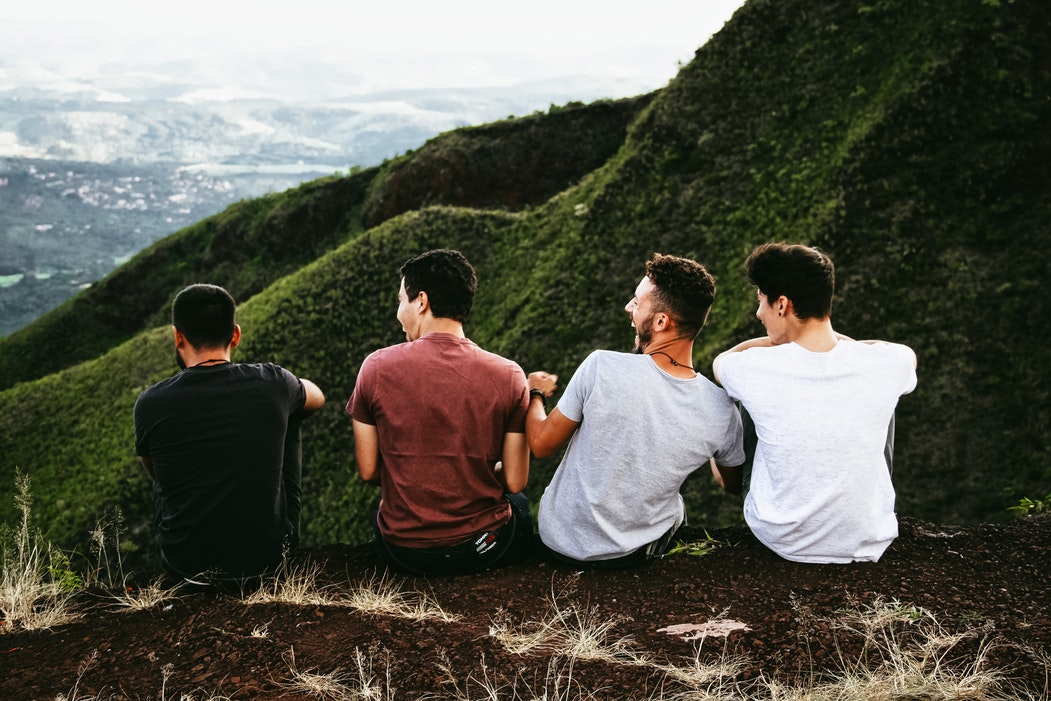 Male travellers sitting on top of hill
